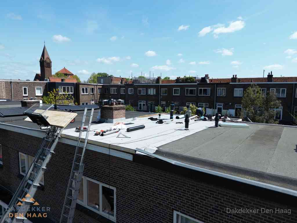 Dakdekkers aan het werk op plat dak in Den Haag Dakdekkers aan het werk op plat dak in Den Haag